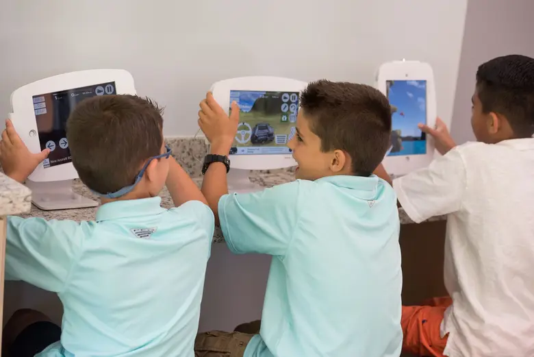 Children engaging with interactive tablets in a welcoming orthodontic office, showcasing Miami Orthodontic Specialists' family-friendly environment and patient-centered care.