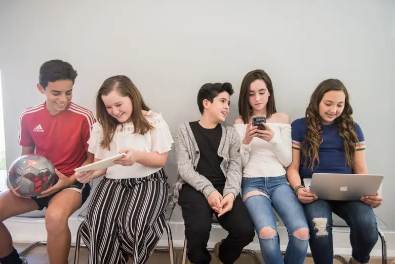 Group of children waiting in a Miami orthodontics office, engaging with devices and a soccer ball, showcasing a welcoming atmosphere for braces and Invisalign treatments.