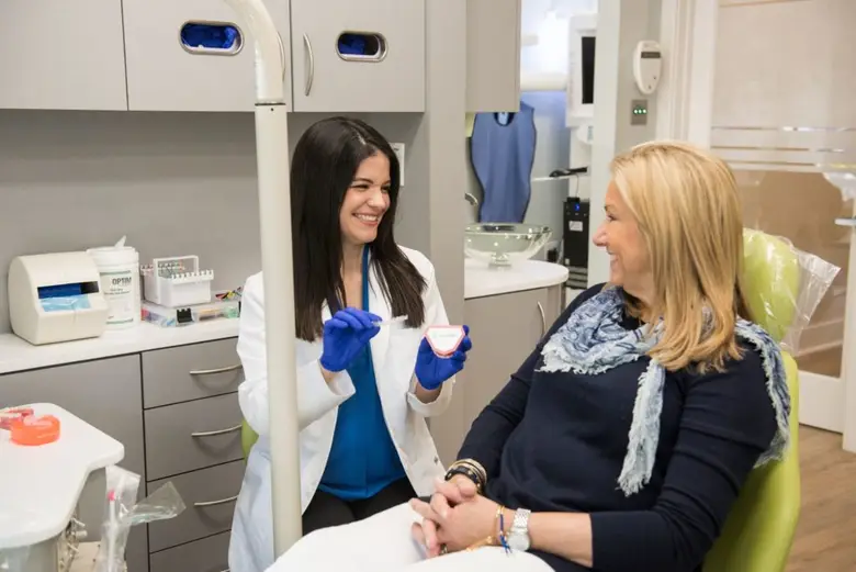 Orthodontist in Miami explaining treatment options to a patient in a modern, private care room at Miami Braces, emphasizing a comfortable and welcoming environment for braces and Invisalign consultations.