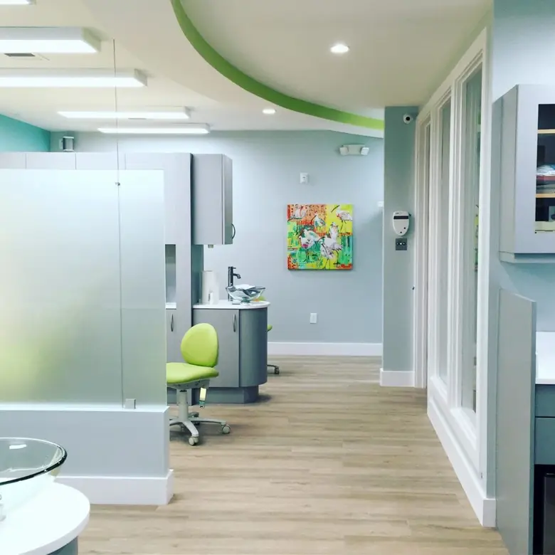 Modern orthodontic office interior featuring private treatment rooms, green accents, and a welcoming atmosphere, emphasizing comfort for patients at Miami Orthodontic Specialists.
